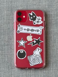 an iphone case with stickers on it sitting on top of a gray cloth covered surface