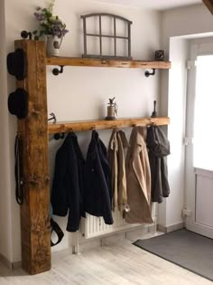 the coat rack is made from wood and has hooks on it, along with several coats