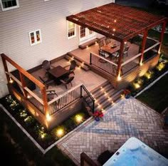 an overhead view of a patio and hot tub at night with lights on the deck