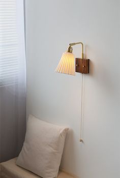 a lamp on the wall next to a pillow