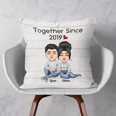 a personalized pillow with two people sitting on the floor and holding each other's hands