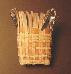 there is a small basket made out of wood and metal scissors in the bottom half