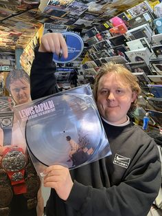 a man holding up a record in front of his face