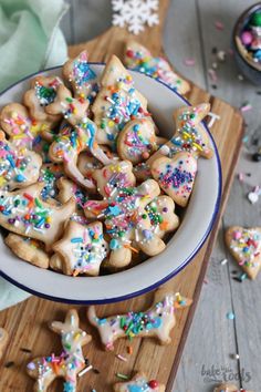 a bowl filled with decorated cookies on top of a wooden table