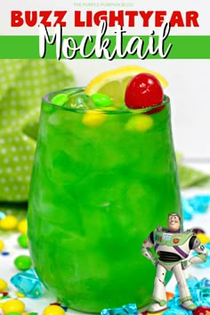 buzz lightyear cocktail in a green glass with a cherry on the rim and sprinkles around it