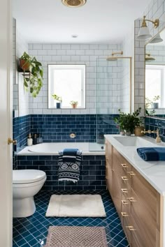 a bathroom with blue tile and wooden cabinets