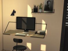 a computer monitor sitting on top of a wooden desk next to a black chair and shelf