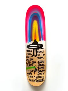 a skateboard that has been painted with different colors and words on the bottom half of it