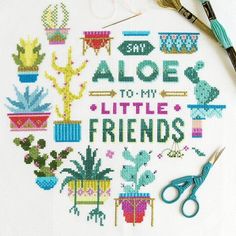 cross stitch pattern with scissors and needle on white table cloth that says aloe to my little friends