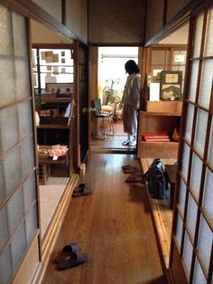 a person standing in an open room with shoes on the floor