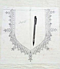 a pen is sitting on top of an open book with intricate designs and border around it