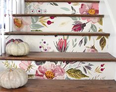 the stairs are decorated with floral wallpaper and pumpkins