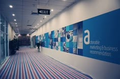 an office hallway with striped carpet and large blue sign on the wall that says corporate marketing, increment