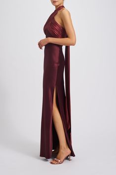 a woman in a long maroon dress with a slit down the side and one leg