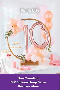 a table with balloons, cake and decorations for a 10th birthday party in pink and gold