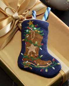 a christmas stocking ornament on top of a gift box