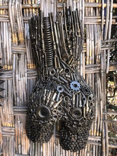 a sculpture made out of metal gears and chains on a wicker wall hanging from the ceiling