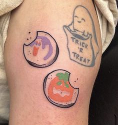 some tattoos on someone's leg that have trick or treat designs on them