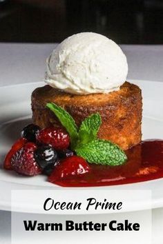 a piece of cake sitting on top of a white plate covered in ice cream and berries