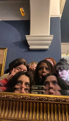 a group of people taking a selfie in front of a mirror with the reflection of them