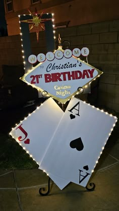 a lighted sign that says 21st birthday with playing cards in front of it and lights on the back