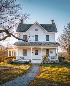 a white house sitting on top of a lush green field