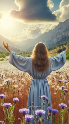 a woman standing in a field with her arms wide open and the sun shining behind her