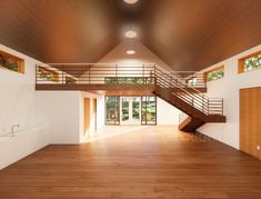 an empty room with wooden floors and stairs