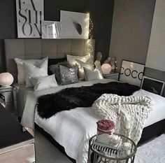 a bedroom with white and black decor on the walls, flooring and bedding