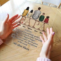 two hands are reaching for a paper cutout with the words papa and three people sitting on a bench