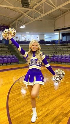 a cheerleader is posing on the basketball court with her pom - poms