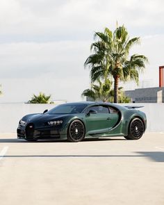 a green bugatti parked in a parking lot next to palm trees and buildings