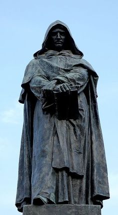 a statue of a person with a book in their hands and a sky background behind it