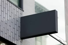 a black sign hanging from the side of a building