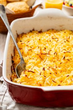 a casserole dish with cheese and bread in it on a table next to other dishes