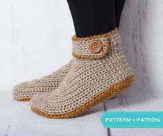 a close up of a person wearing crocheted shoes with buttons on the side