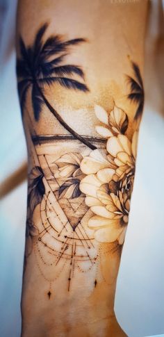 a woman's arm with flowers and palm trees on it