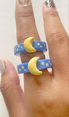 a woman's hand wearing two rings with moon and stars on the middle one