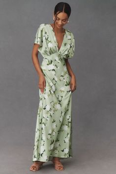 a woman wearing a green floral print dress