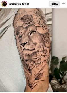 a man with a lion and flowers tattoo on his arm is holding a phone in front of him