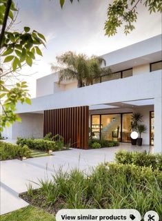 an image of a modern house with trees and plants in the front yard, as seen on instagram