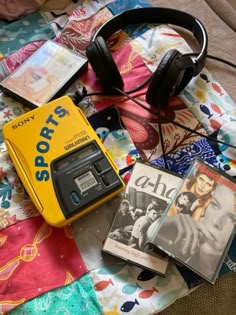 there is a radio, headphones and books on the bed