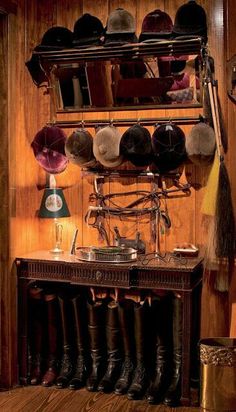 an old fashioned kitchen with lots of pots and pans on the shelf above it