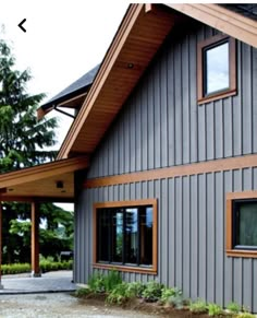 a gray house with wood trim and windows