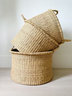 three woven baskets stacked on top of each other, one with an open lid and the other without