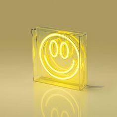 an illuminated square object with a smiley face on it's front and side sides