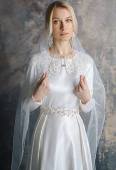 a woman in a white wedding dress and veil