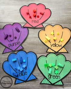 four different colored paper hearts with the words red, purple, green and blue written on them