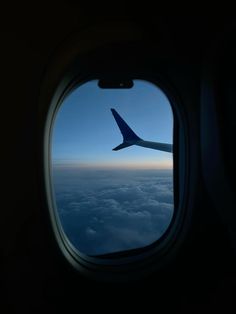 an airplane window looking out at the clouds