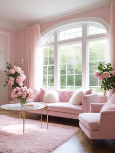 a living room with pink furniture and flowers on the table in front of large windows